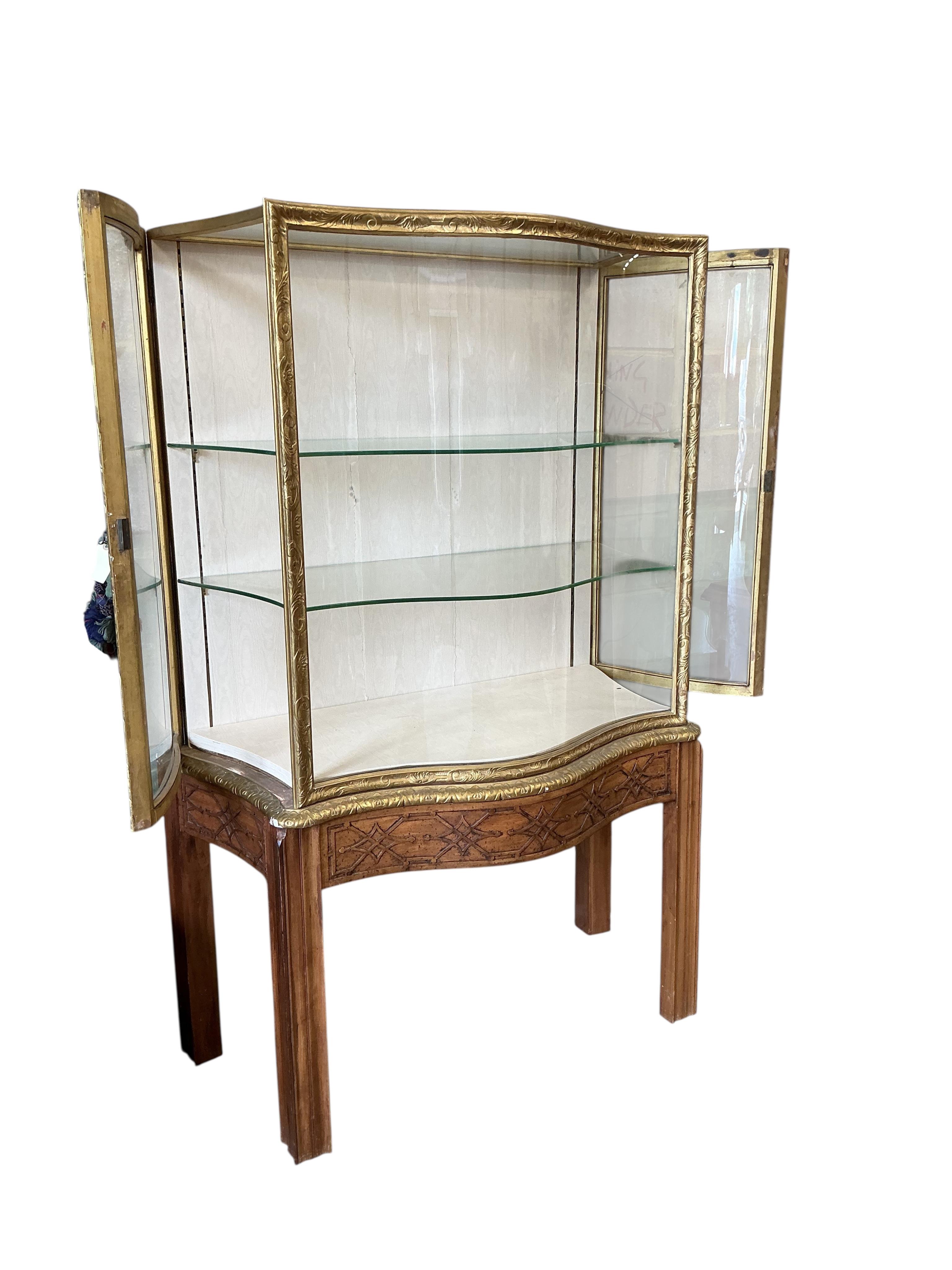 A George III style mahogany and giltwood serpentine display cabinet on blind fret stand, width 106cm, depth 60cm, height 181cm